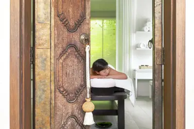 a woman laying on a chair in a room at The Pavilions Phuket in Bang Tao Beach