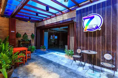 a patio with tables and chairs in front of a building at 7Q Patong Beach Hotel in Patong Beach