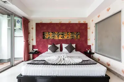 a bedroom with a large bed with a red headboard at 7Q Patong Beach Hotel in Patong Beach