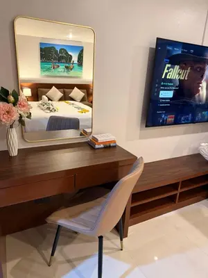 a bedroom with a bed and a desk with a mirror at Sea Hills Resort in Patong Beach