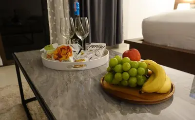 a table with a tray of fruit and wine glasses at Sea Hills Resort in Patong Beach
