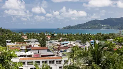 a city with houses and trees and the ocean at Sea Hills Resort in Patong Beach