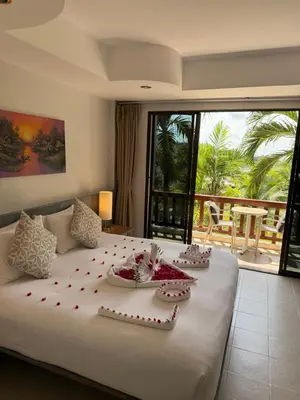 a bedroom with a large white bed with decorations on it at Sea Hills Resort in Patong Beach