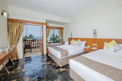 a hotel room with two beds and a balcony at Karona Resort & Spa - SHA Extra Plus in Karon Beach