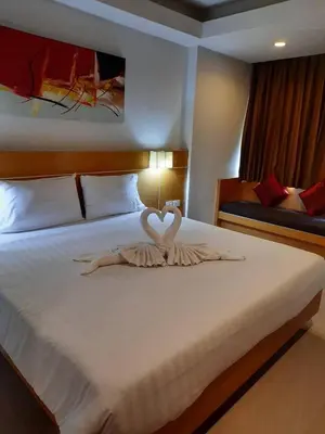 a bedroom with a bed with two swans forming a heart at Aspery Hotel in Patong Beach