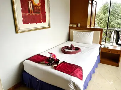 a hotel room with a bed with flowers on it at Patong Lamai Residence in Patong Beach