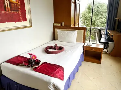 a hotel room with a bed with flowers on it at Patong Lamai Residence in Patong Beach
