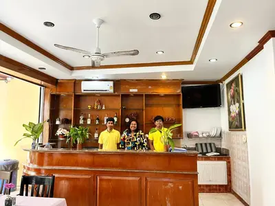 three people standing at a bar in a restaurant at Patong Lamai Residence in Patong Beach