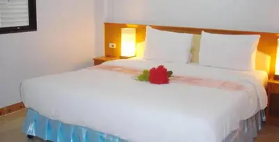 a large white bed with a red flower on it at Patong Lamai Residence in Patong Beach