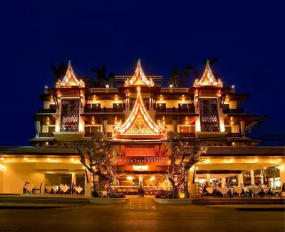 a large building with lights on it at night at Rayaburi Hotel, Patong in Patong Beach