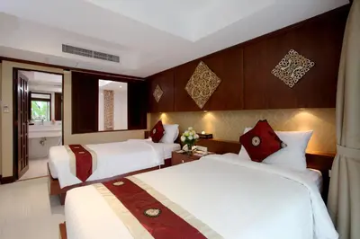 a hotel room with two beds and a bathroom at Rayaburi Hotel, Patong in Patong Beach