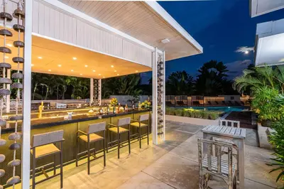 a patio with a bar and a swimming pool at Dewa Phuket Resort & Villas, Nai Yang Beach in Nai Yang Beach
