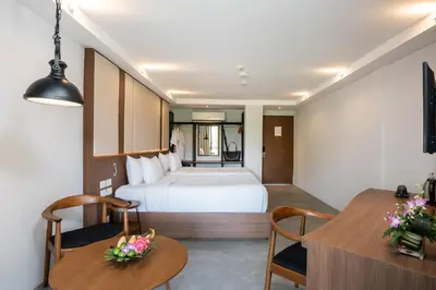 a hotel room with a bed and a table and chairs at Dewa Phuket Resort & Villas, Nai Yang Beach in Nai Yang Beach
