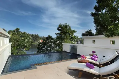 a swimming pool on the roof of a house with purple pillows at Dusit Thani Laguna Phuket in Bang Tao Beach