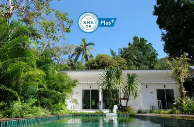 a building with a swimming pool in front of it at Whalecome Aonang Resort-SHA Extra Plus in Ao Nang Beach