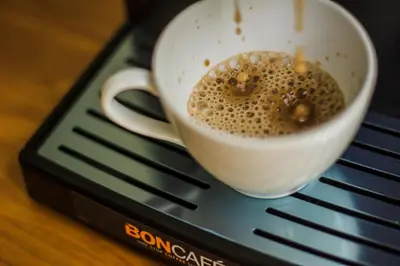 a cup of coffee sitting on top of a keyboard at Whalecome Aonang Resort-SHA Extra Plus in Ao Nang Beach