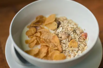 a bowl of cereal and nuts on a plate at Whalecome Aonang Resort-SHA Extra Plus in Ao Nang Beach