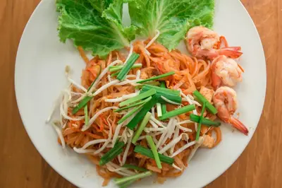 a white plate of food with shrimp and lettuce at Whalecome Aonang Resort-SHA Extra Plus in Ao Nang Beach