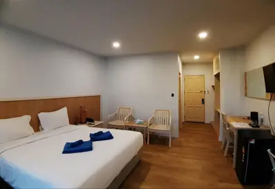 a hotel room with a bed and a table and chairs at Karon Living Room - SHA Plus in Karon Beach