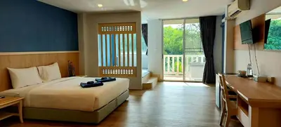 a bedroom with a bed and a desk and a window at Karon Living Room - SHA Plus in Karon Beach