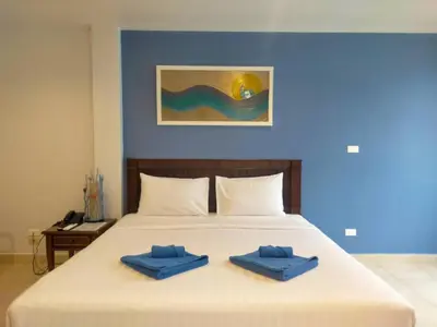 a bed with two blue towels on top of it at Karon Living Room - SHA Plus in Karon Beach