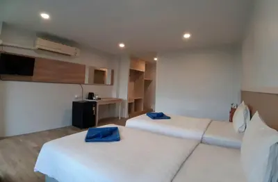 a hotel room with two beds with blue pillows at Karon Living Room - SHA Plus in Karon Beach
