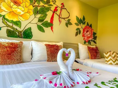 two swans are sitting on a bed in a room at Sino House Phuket Hotel - SHA Plus in Phuket Town
