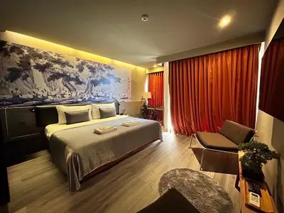 a hotel room with a bed and a painting on the wall at Sino House Phuket Hotel - SHA Plus in Phuket Town
