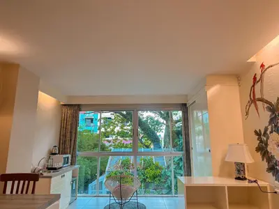 a room with a large window and a table and a desk at Sino House Phuket Hotel - SHA Plus in Phuket Town
