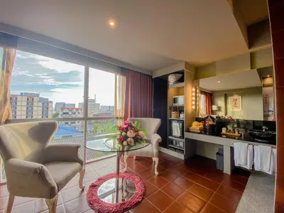 a living room with a table and a large window at Sino House Phuket Hotel - SHA Plus in Phuket Town
