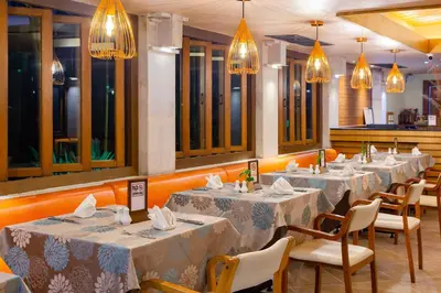 a row of tables in a restaurant with lights at Seaview Patong Hotel - SHA Plus in Patong Beach