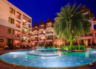 a large swimming pool with a palm tree in front of a building at Seaview Patong Hotel - SHA Plus in Patong Beach