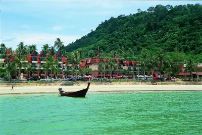 a boat in the water next to a beach at Seaview Patong Hotel - SHA Plus in Patong Beach