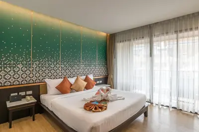 a bedroom with a large bed with a green wall at Ananta Burin Resort in Ao Nang Beach