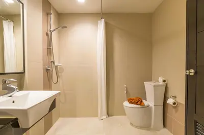 a bathroom with a shower and a toilet and a sink at Ananta Burin Resort in Ao Nang Beach