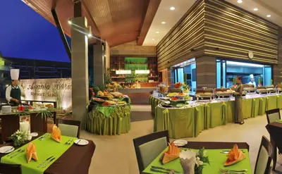 a restaurant with green tables and a buffet at Ananta Burin Resort in Ao Nang Beach