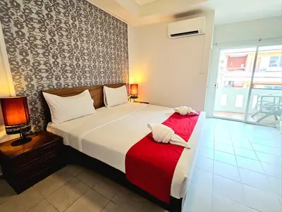 a bedroom with a large bed with a red blanket at The Album Loft in Patong Beach