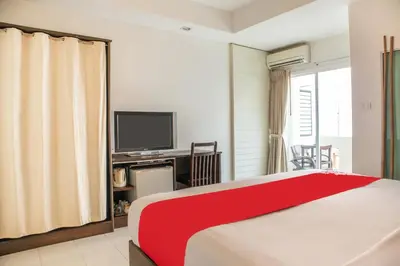 a hotel room with a bed and a television at The Album Loft in Patong Beach