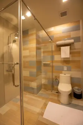 a bathroom with a toilet and a glass shower at Holiday Ao Nang Beach Resort, Krabi in Ao Nang Beach