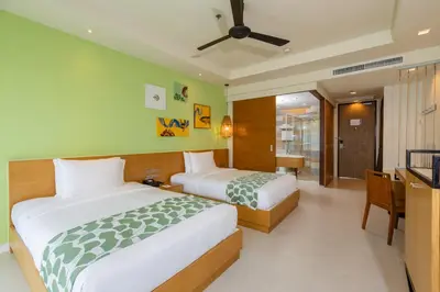 a hotel room with two beds and a television at Holiday Ao Nang Beach Resort, Krabi in Ao Nang Beach