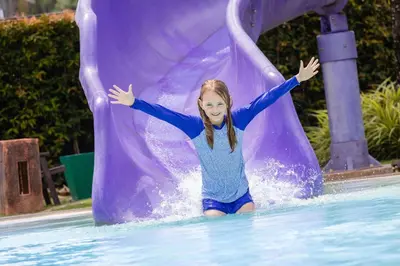 a young girl on a slide in a pool at Holiday Ao Nang Beach Resort, Krabi in Ao Nang Beach