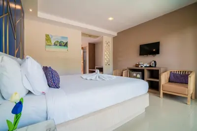 a bedroom with a large white bed and a chair at Phi Phi Anita Resort in Phi Phi Don