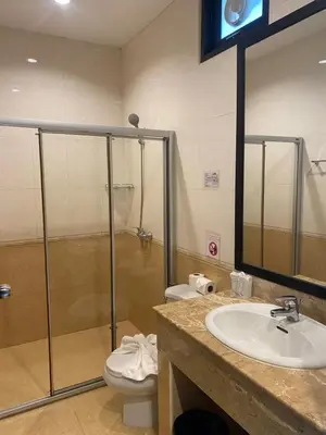 a bathroom with a shower and a sink and a toilet at Rawai Grand House -SHA Plus in Rawai Beach