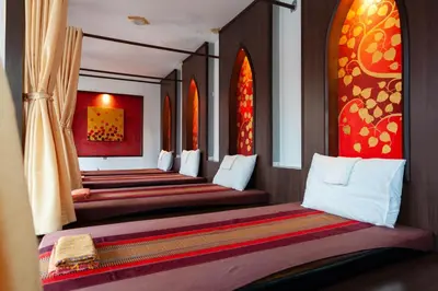 a row of beds lined up in a room with windows at Baumancasa Beach Resort in Karon Beach