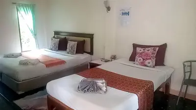 a room with two beds and a window at Aonang Green Park Bungalow in Ao Nang Beach