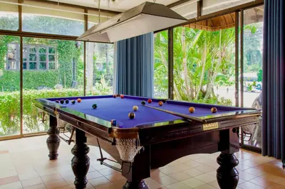 a pool table in a room with windows at Klong Muang Sunset House in Klong Muang Beach