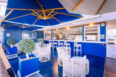 a restaurant with blue walls and white chairs at Hotel Clover Patong Phuket - SHA Plus in Patong Beach