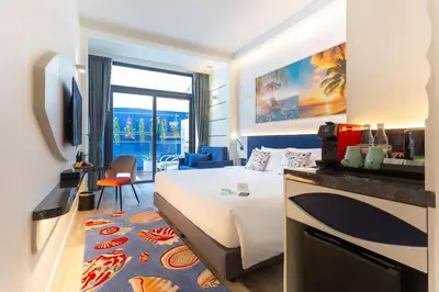 a hotel room with a bed and a living room at Hotel Clover Patong Phuket - SHA Plus in Patong Beach