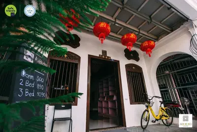a bike parked in front of a building with red lanterns at Aekkeko hostel in Phuket Town