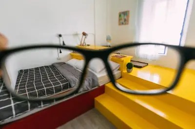 a bedroom with a bed and a pair of glasses at Aekkeko hostel in Phuket Town